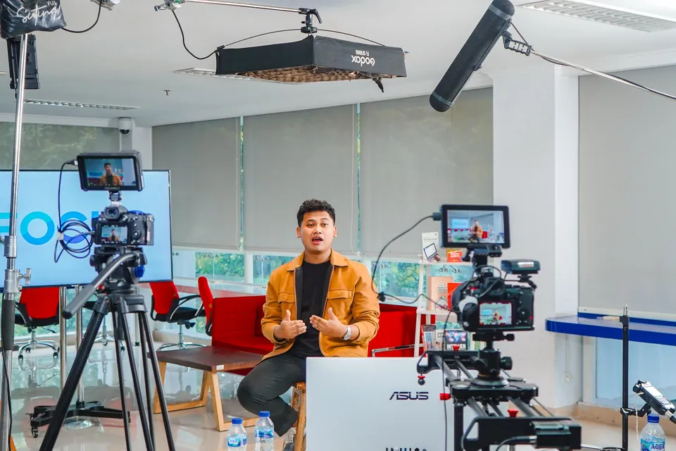 Presenter direkam di studio dengan dua kamera dan lampu produksi